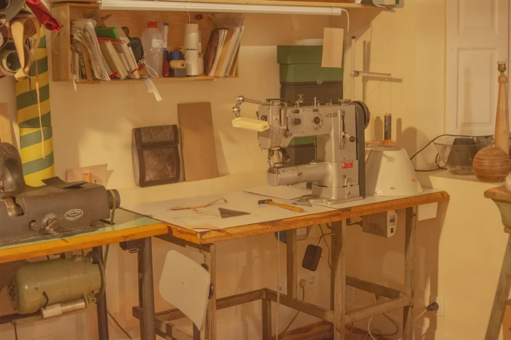 A mechanical sewing machine and a computerized sewing machine sitting side by side on a repair bench