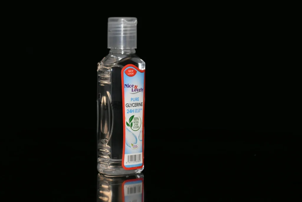 A small bottle of sewing machine oil beside an open Juki TL hook area