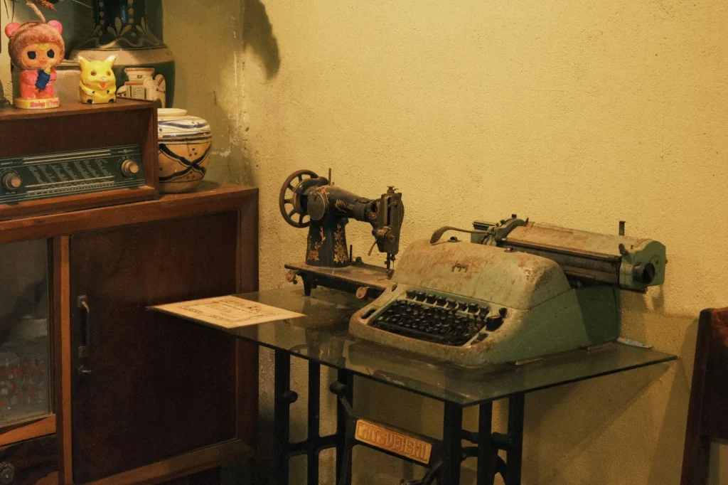 An open wood cabinet sewing machine displayed at an estate sale