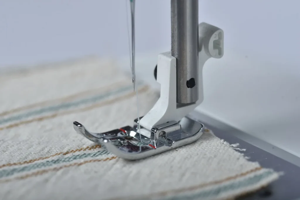 Snipping the top thread near the fabric with the presser foot raised