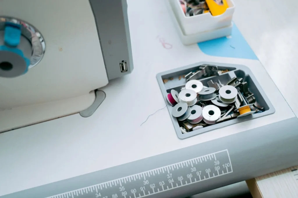 Lint packed around the bobbin race beneath the needle plate of a sewing machine