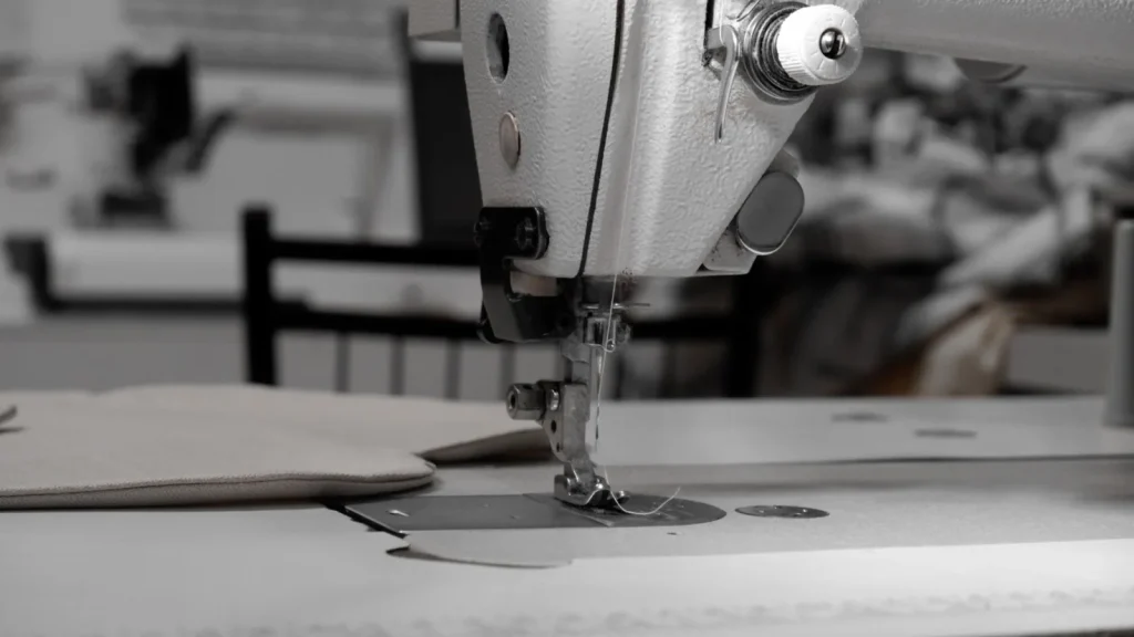 Thread fraying into fuzz just above the eye of a sewing machine needle