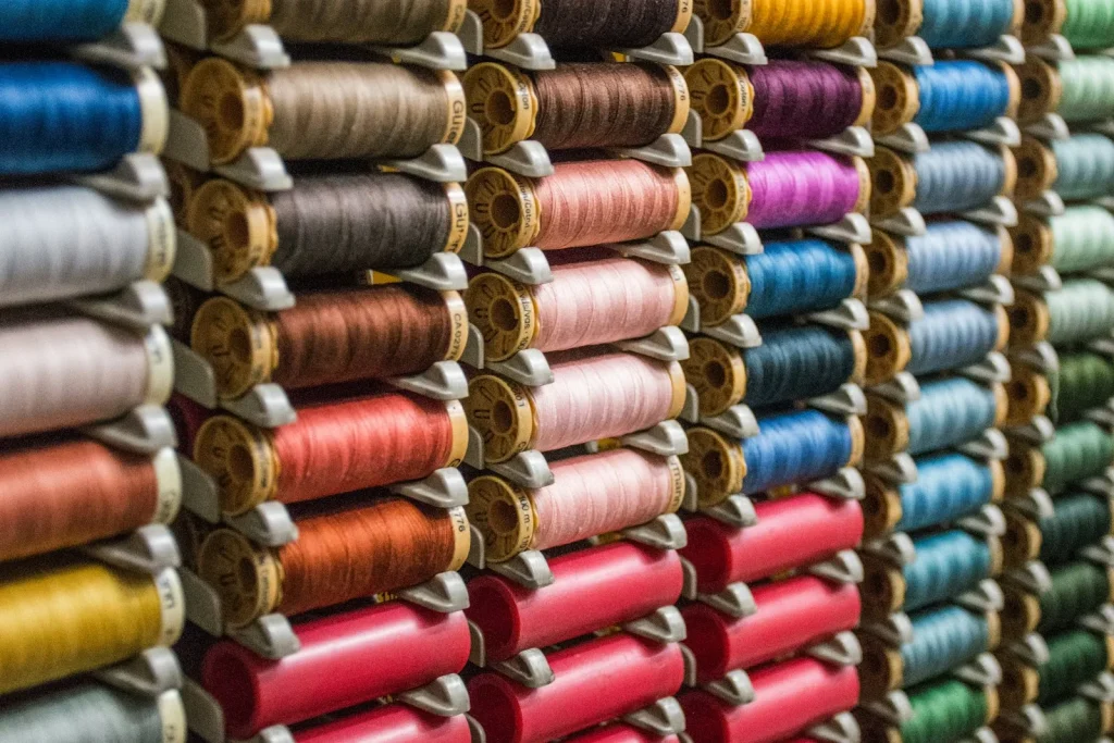 Regular weight bobbin thread beside a heavy topstitching spool