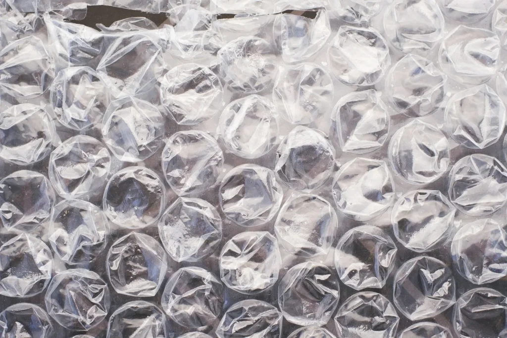 A sewing machine wrapped in bubble wrap taped to itself before boxing